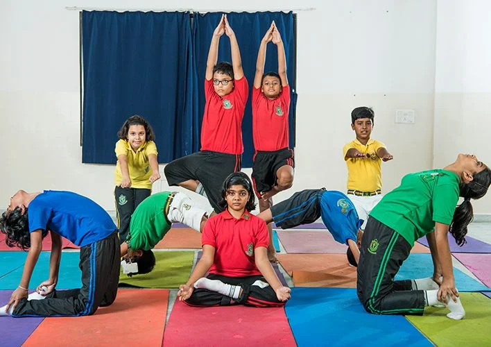 Students practising yoga poses on colourful mats